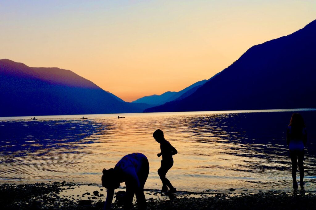 Family silhouettes on a lake at sunset